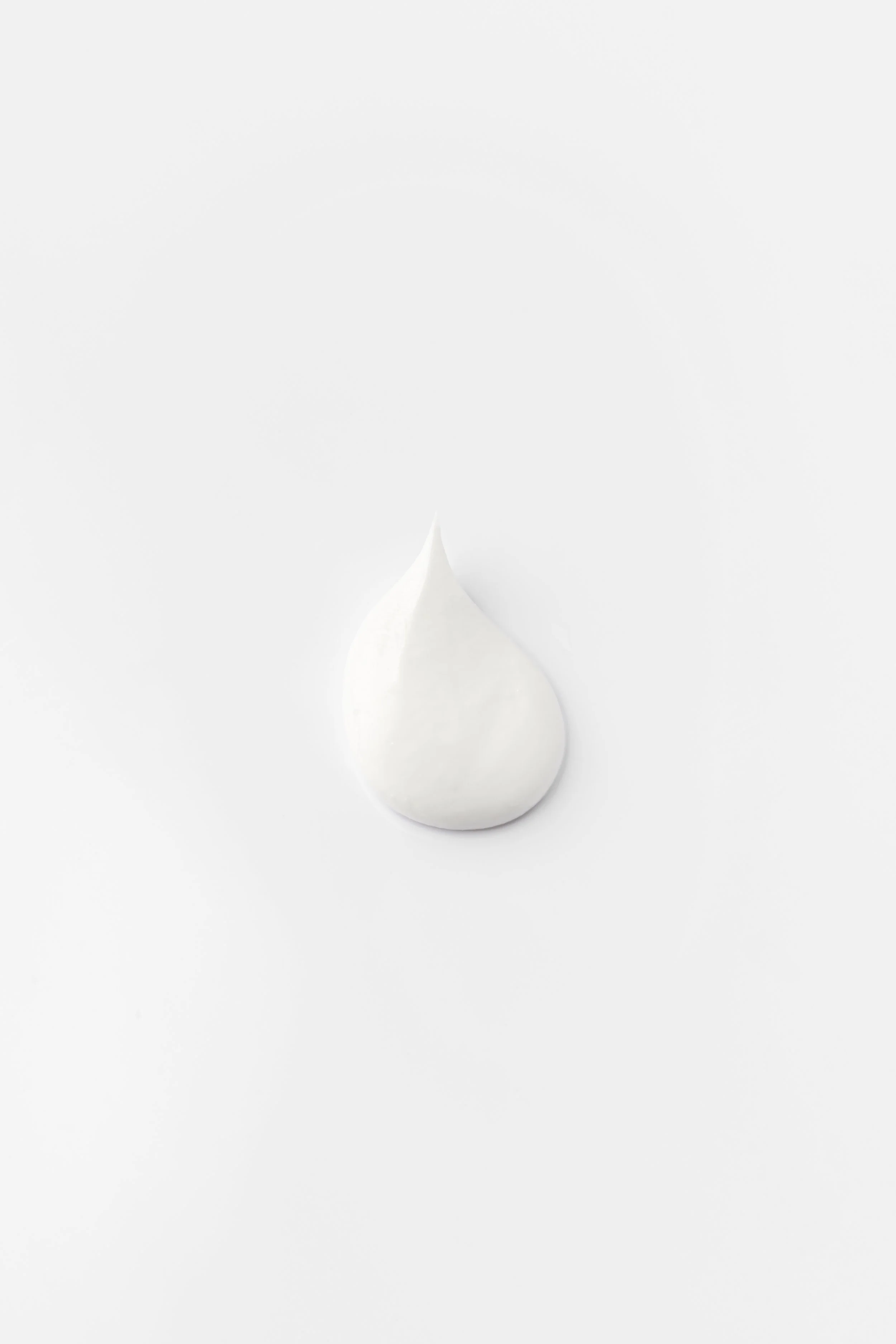 Noget creme med en spids top, ligger på en hvid baggrund.