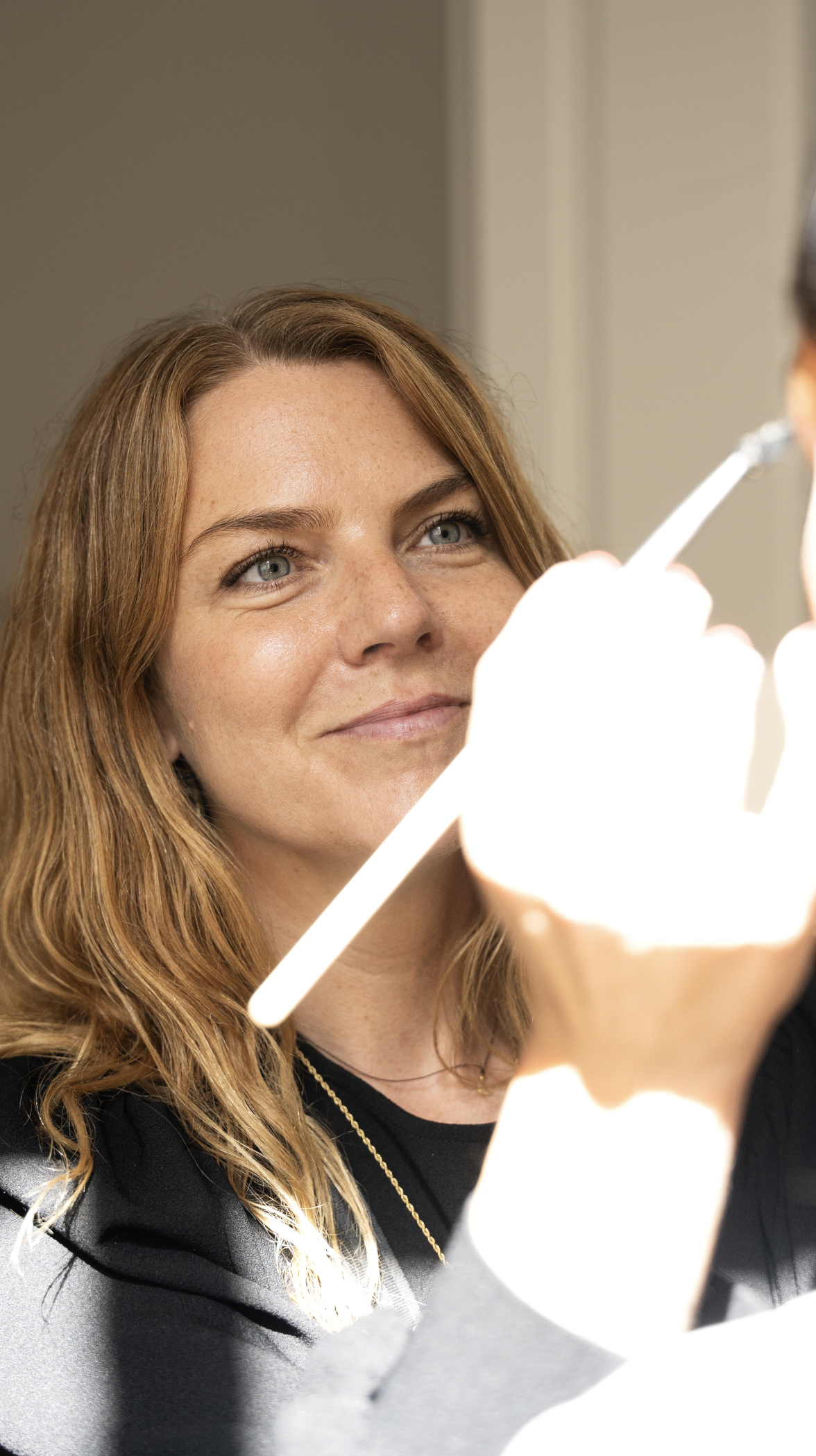 En makeupartist som påfører makeup i hovedet af en person.