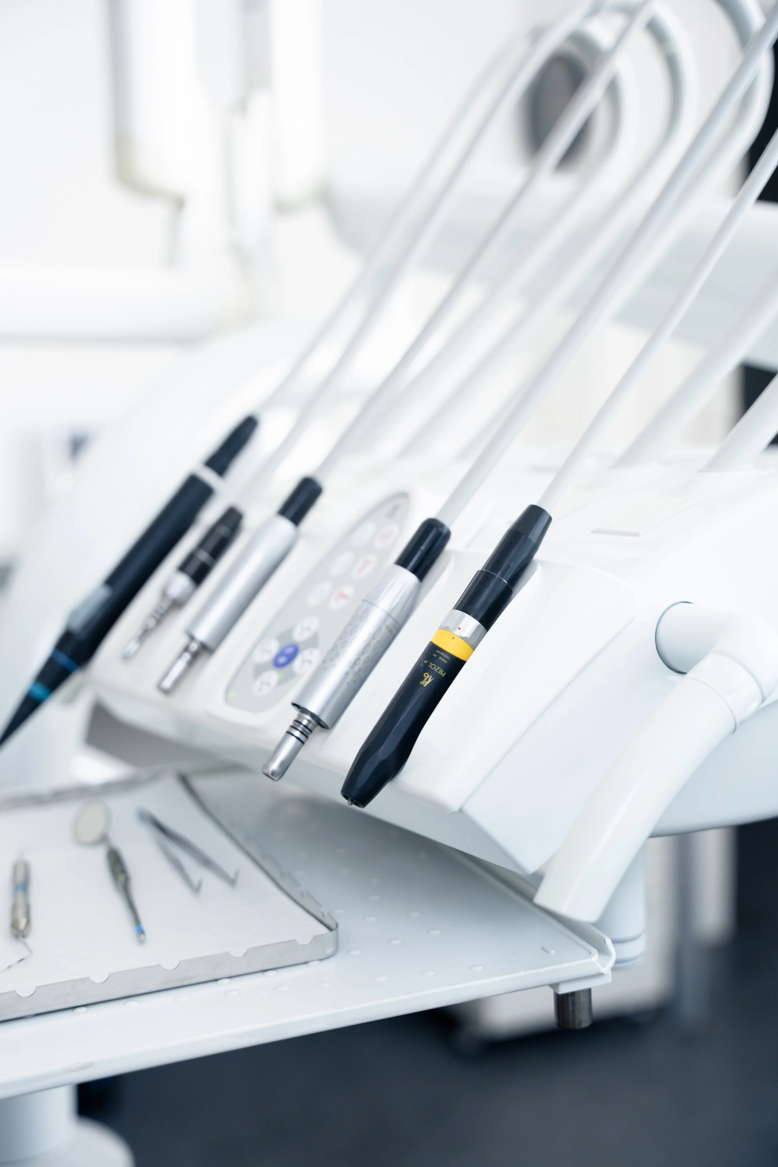 Tandlægeudstyr med forskellige instrumenter og dentalbor i en klinik.