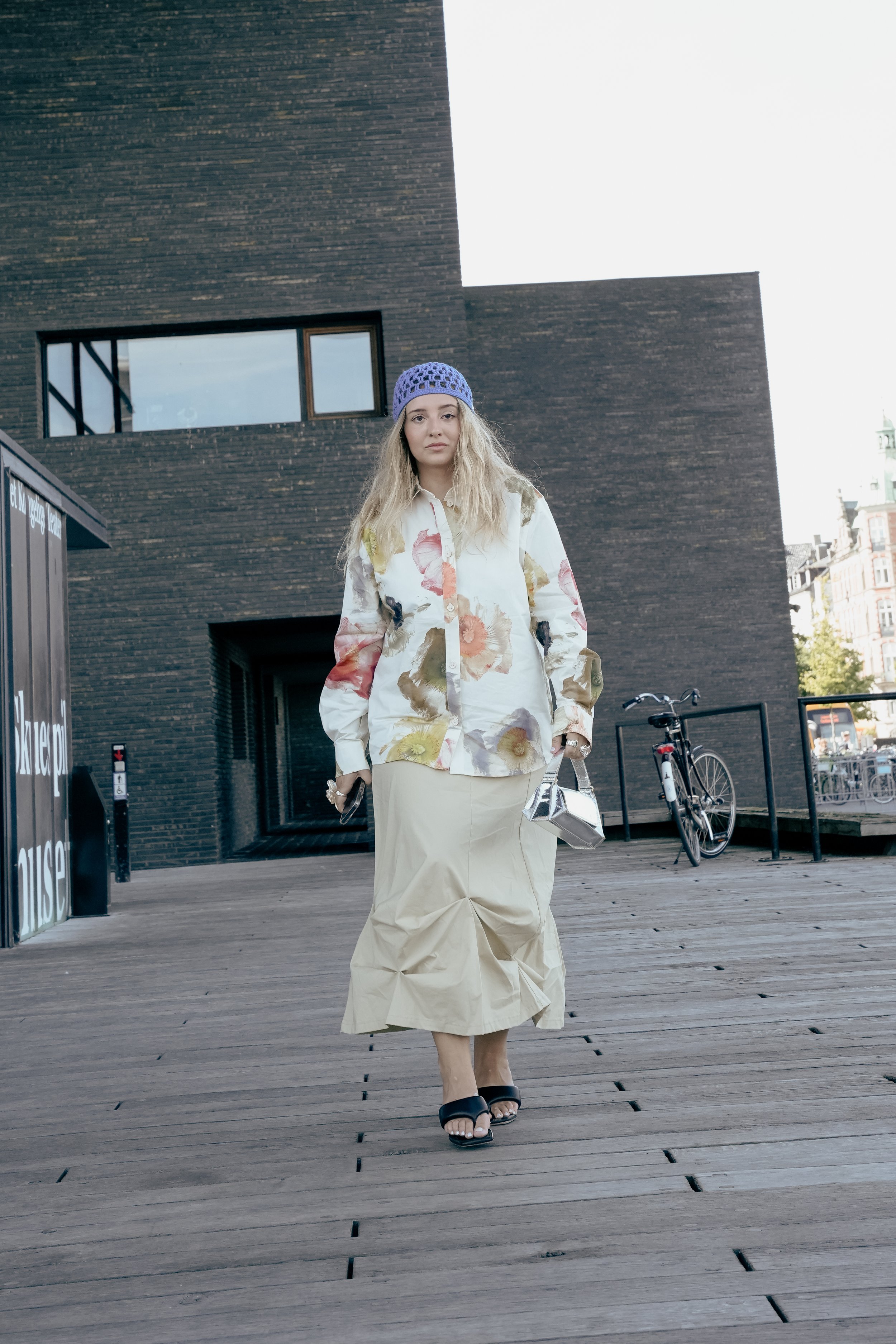 Kvinde går på trædesten i en by udendørs.