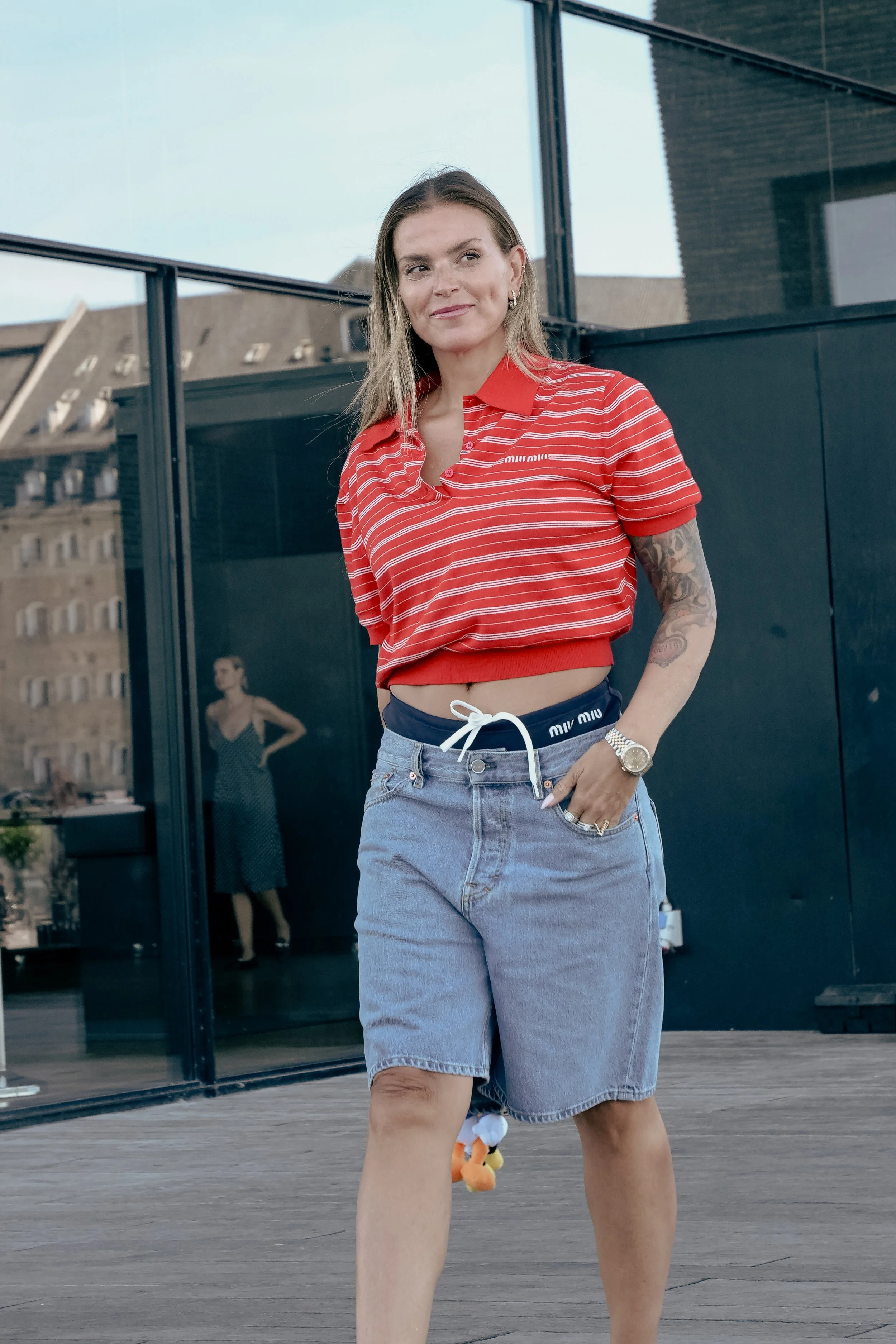 Kvinde i rød stripet T-shirt og baggy jeans udenfor.