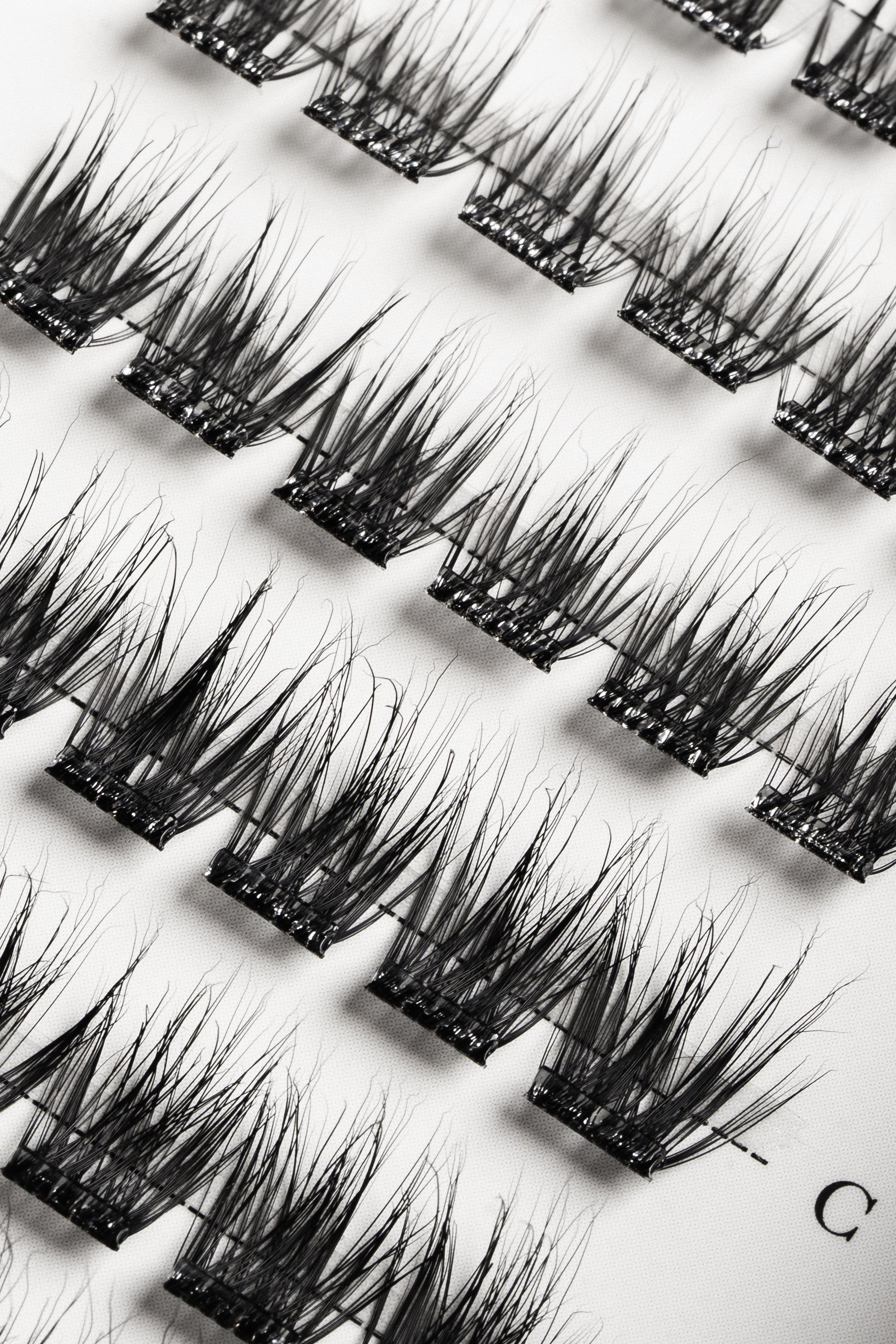 Forskellige falske vipper udstillet på en hvid baggrund.