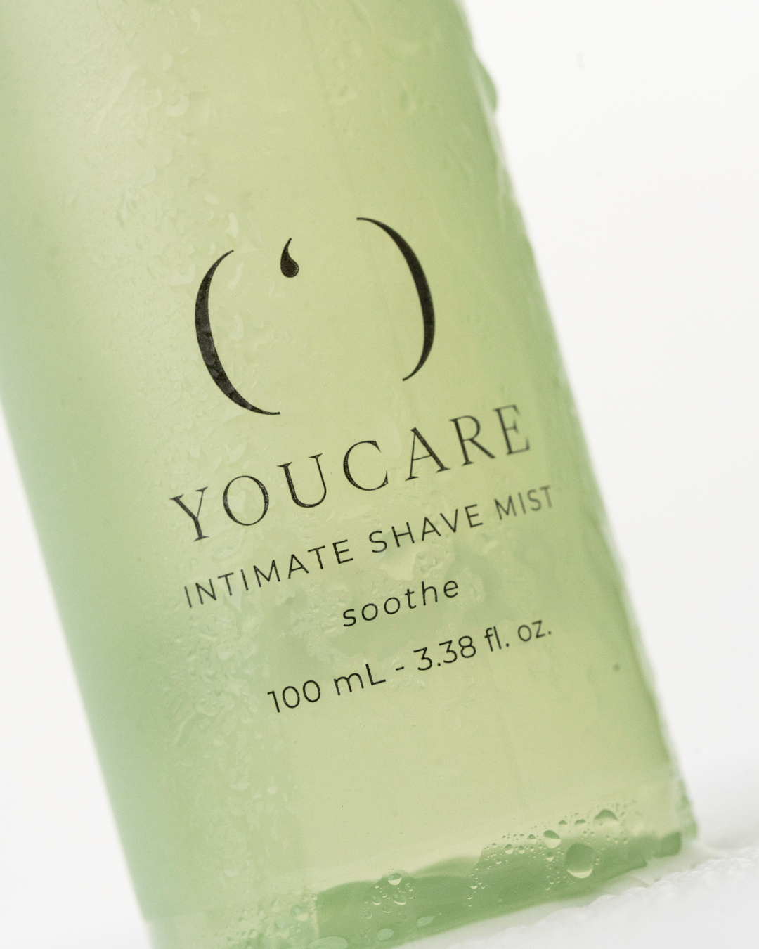 En grøn flaske med etiketten YouCare Intimate Shave Mist, der indeholder 100 ml.