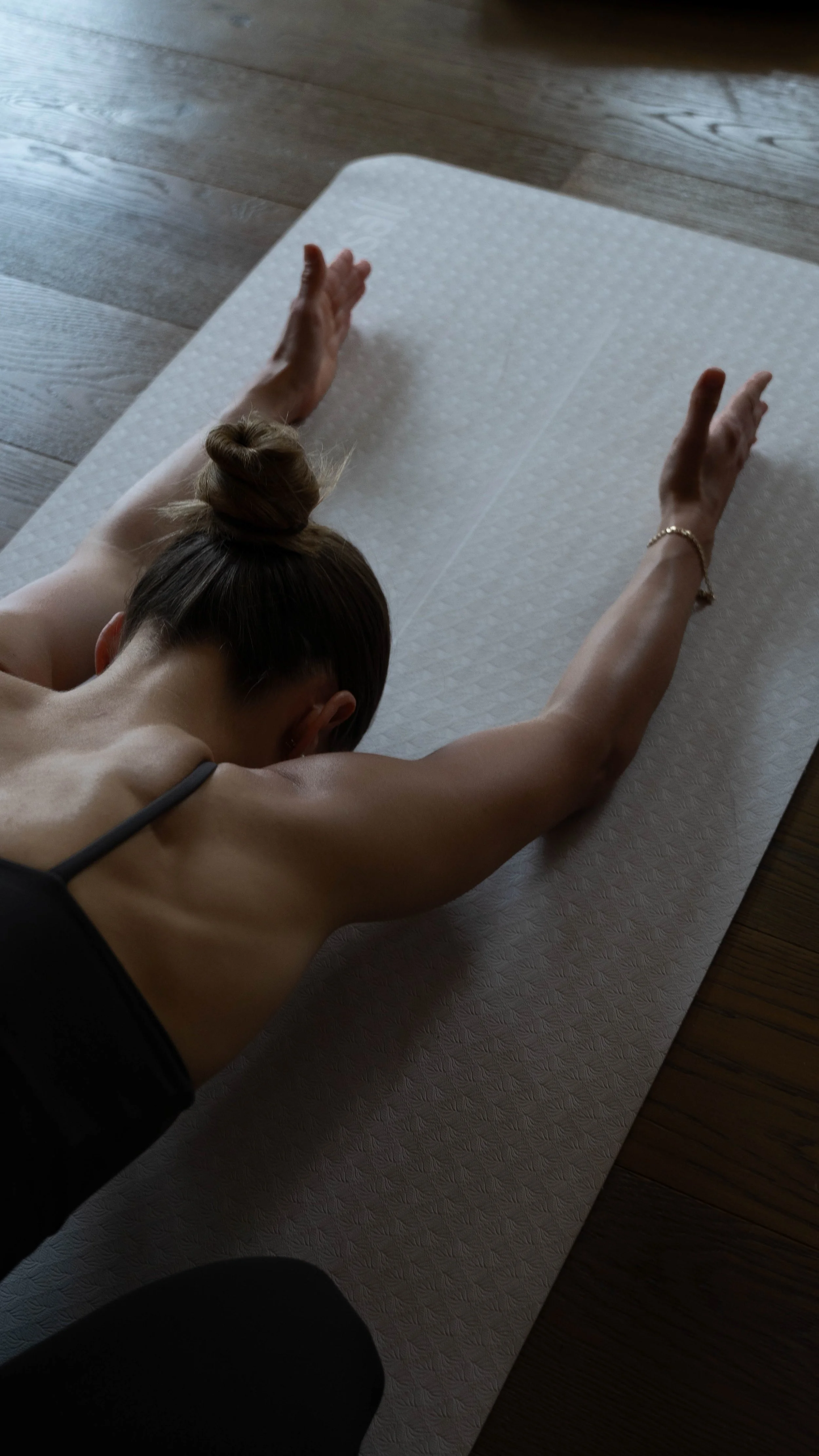 En person laver en yogaøvelse på en yogamåtte på gulvet.