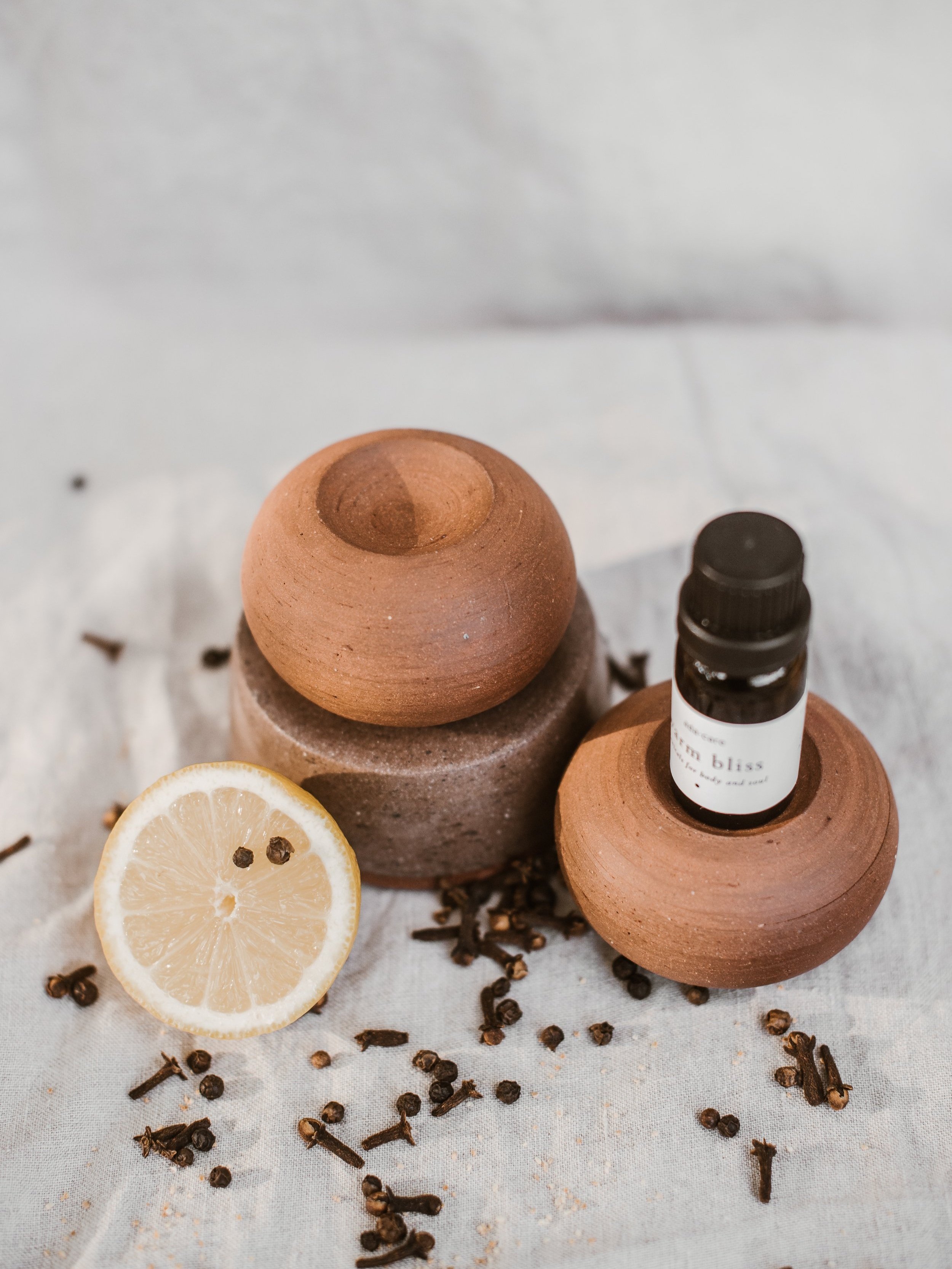 aromasteen round uit keramiek en synergie warm bliss van adacare essentiële oliën