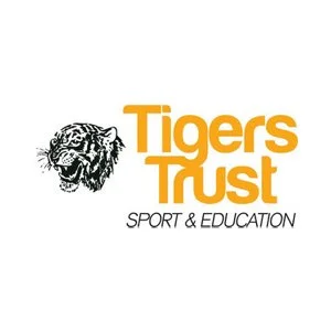 Logo of Tigers Trust featuring a black and white tiger head silhouette and the text 'Tigers Trust' in orange, with 'Sport & Education' in smaller black font.