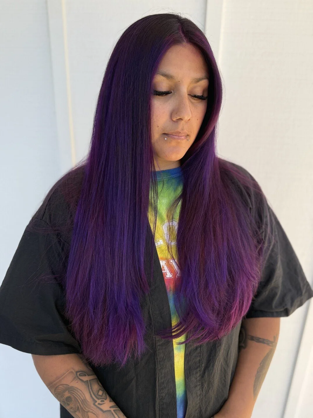 woman with purple long hair looks to the side