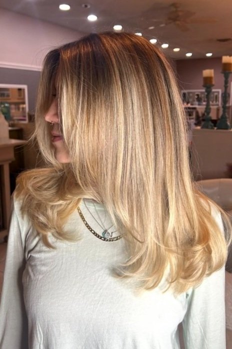 side profile of woman with mid length blonde and caramel highlighted hair