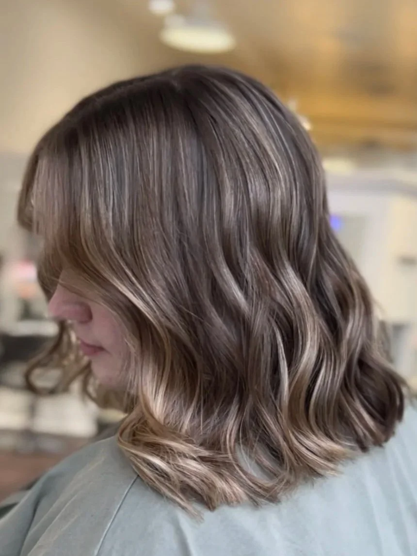 side profile of woman with short, light brown hair with highlights