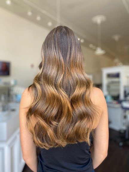 finished work of brown caramel highlighted long dark hair with waves