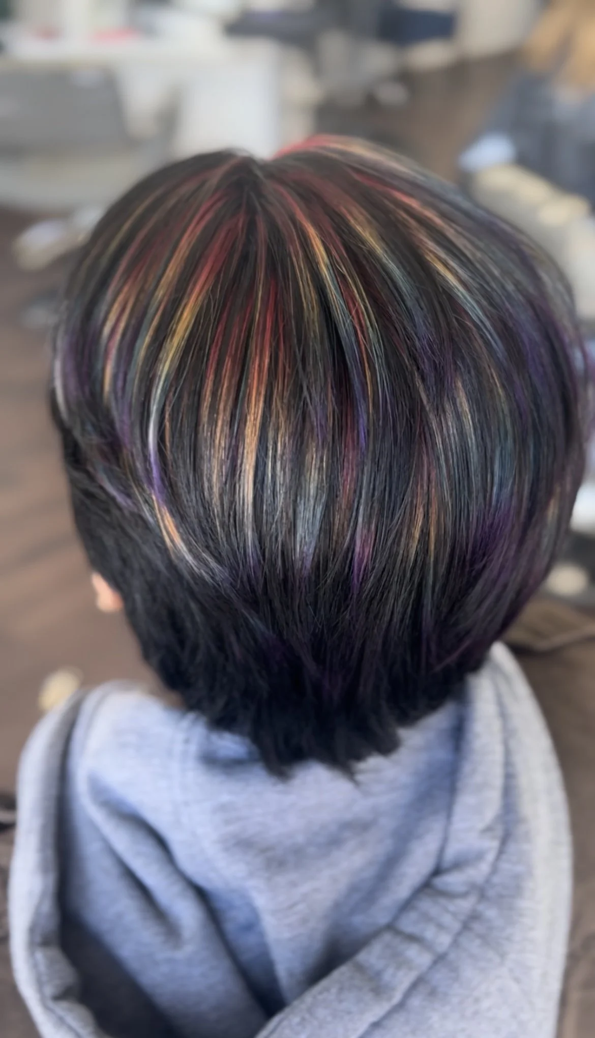 top of woman's short, dark hair with peekaboo rainbow highlights