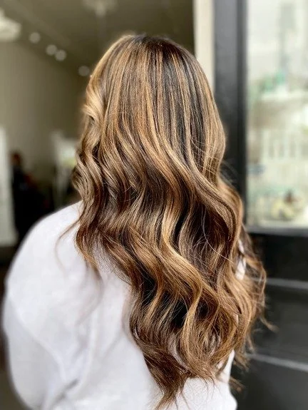 finished work of long caramel brown highlighted dark hair with waves