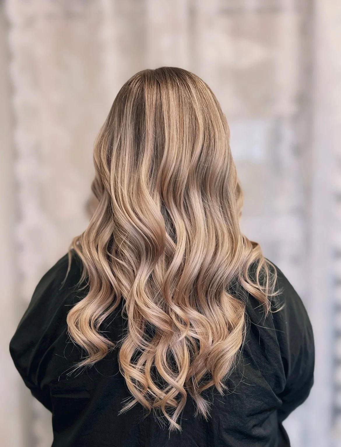 photo of the back of the head of woman with curly dirty blonde hair