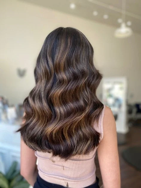 finished work of brown highlighted dark hair with waves