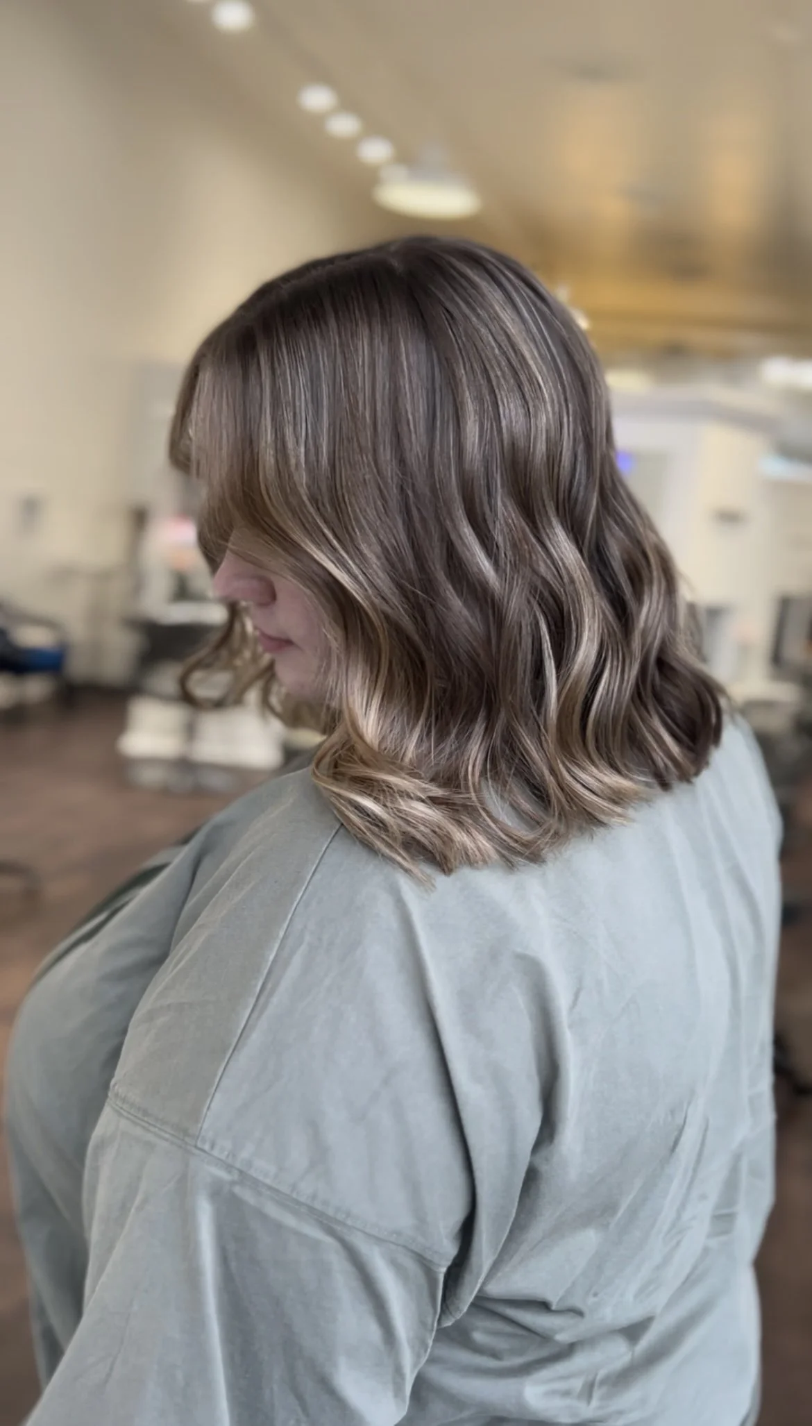 side profile of woman with short, light brown hair with highlights