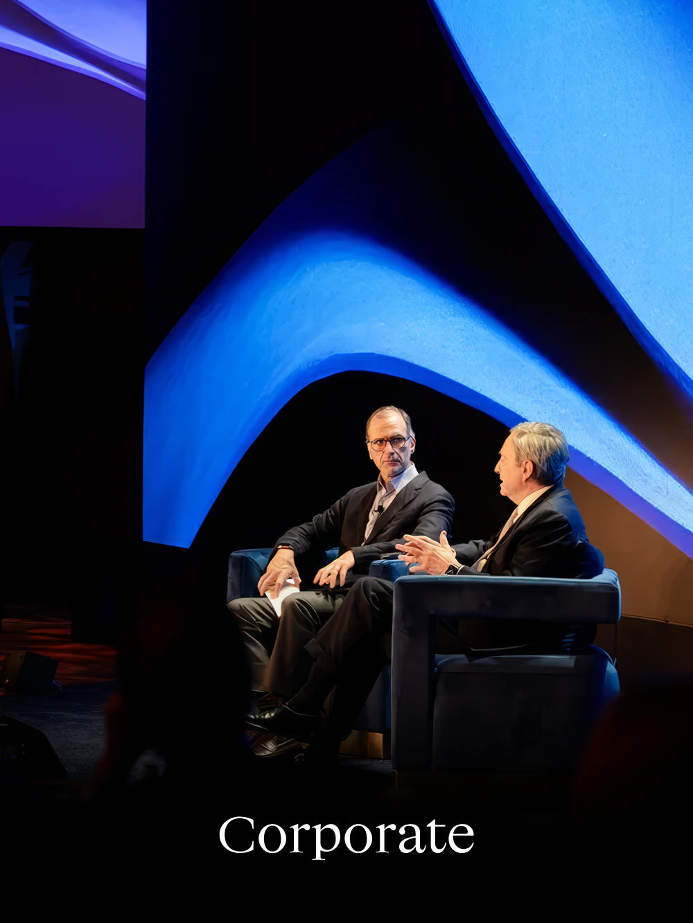 Executive fireside chat at high-end corporate conference with immersive stage design