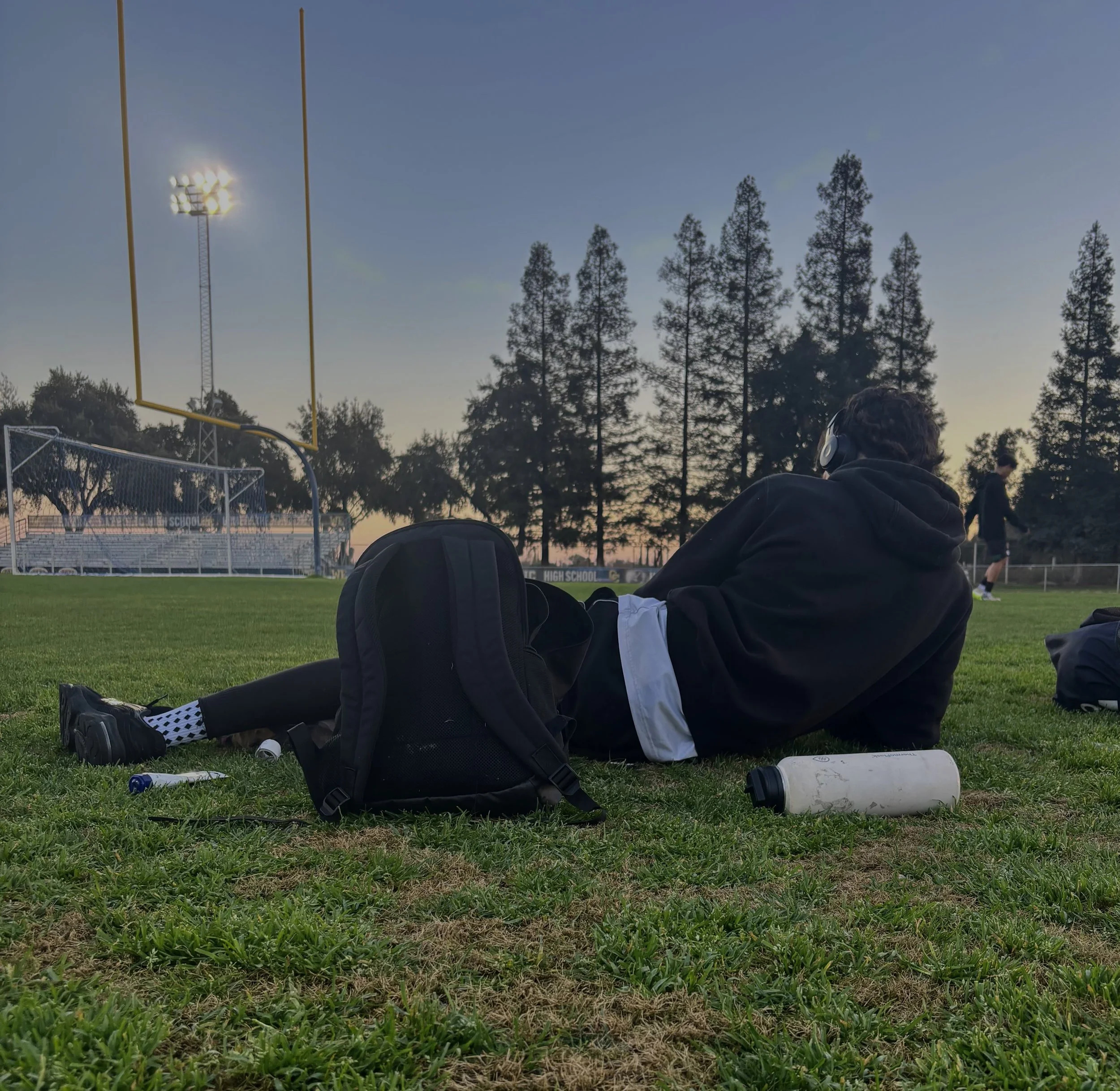  Mateo Esparza watching the JV boys' soccer game while having his music going, implying he Isn’t letting no distractions get on his way against Central Catholic, February 2, 2026. (Christian Ambriz/The Tower)&nbsp; 