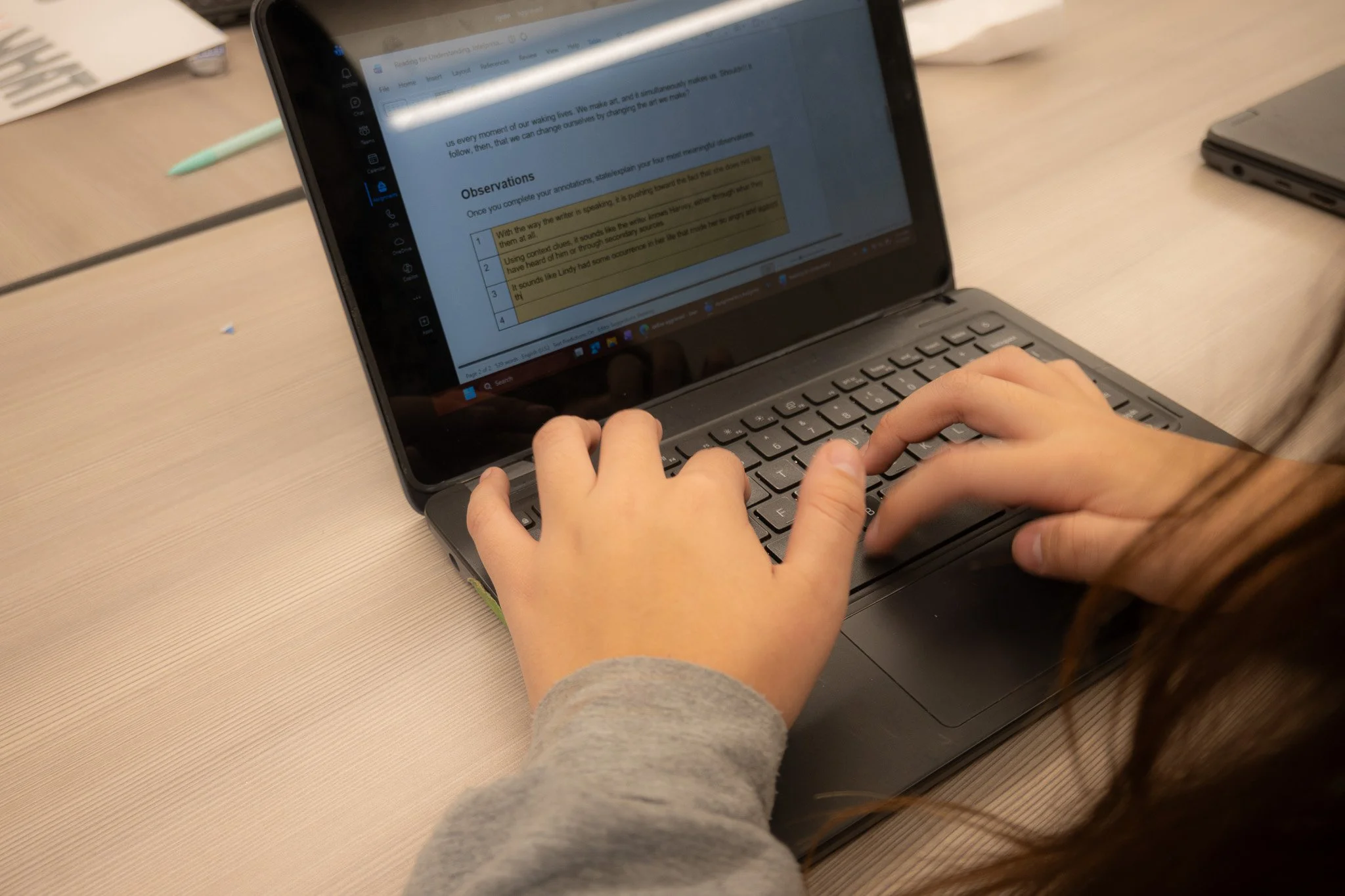 A tennis athlete works on her English honors assignment during class time. 