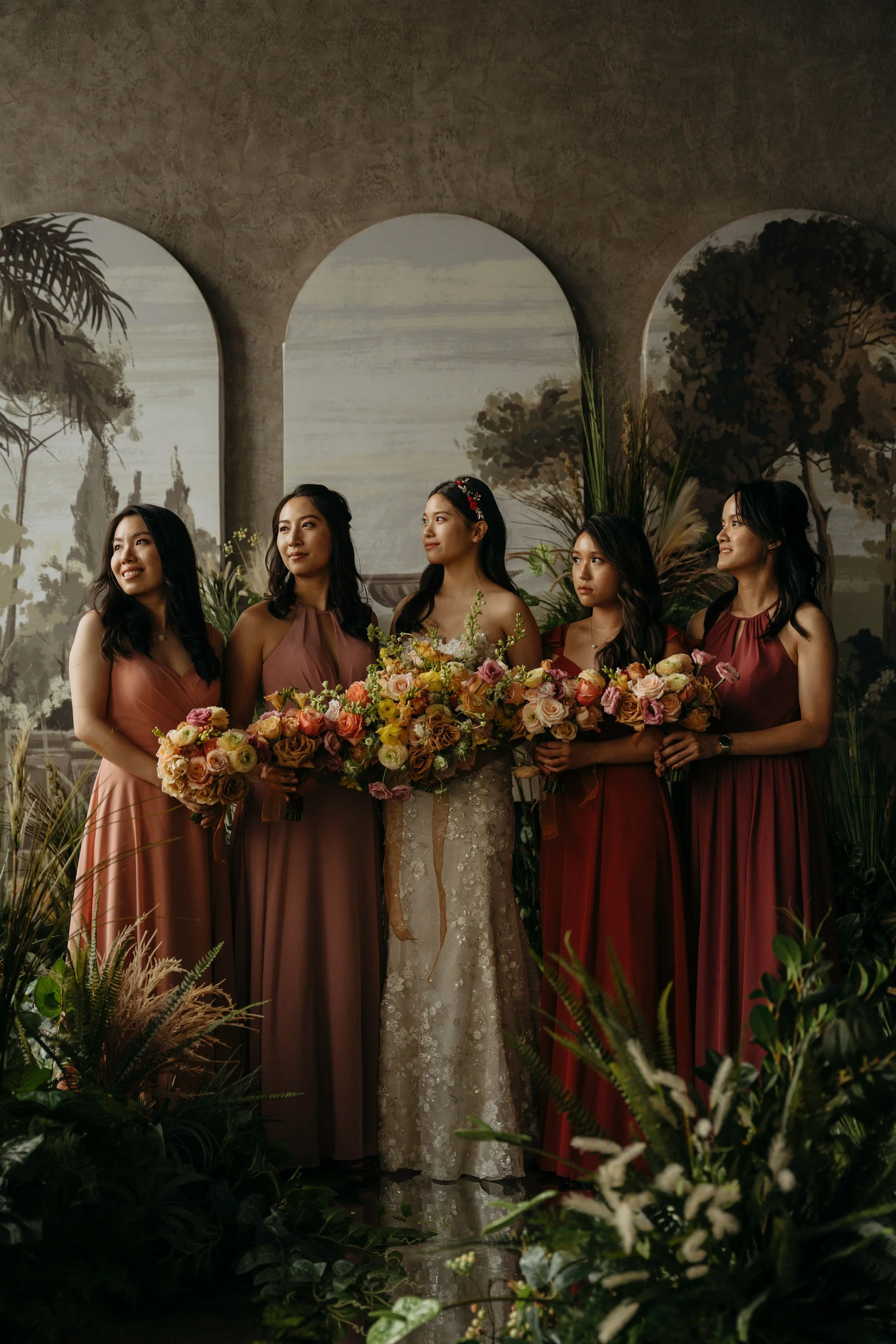 Moody portrait of Bride and bridesmaids in studio filled with florals