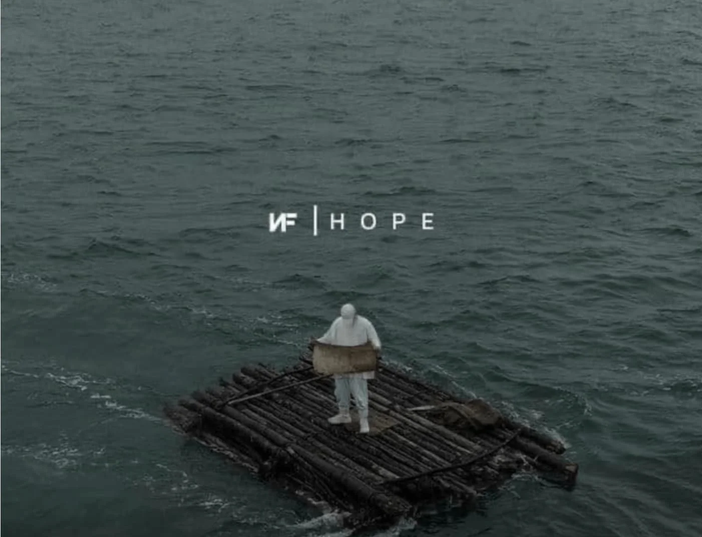 NF in white standing on a small wooden raft in the ocean in artwork from the Hope album.