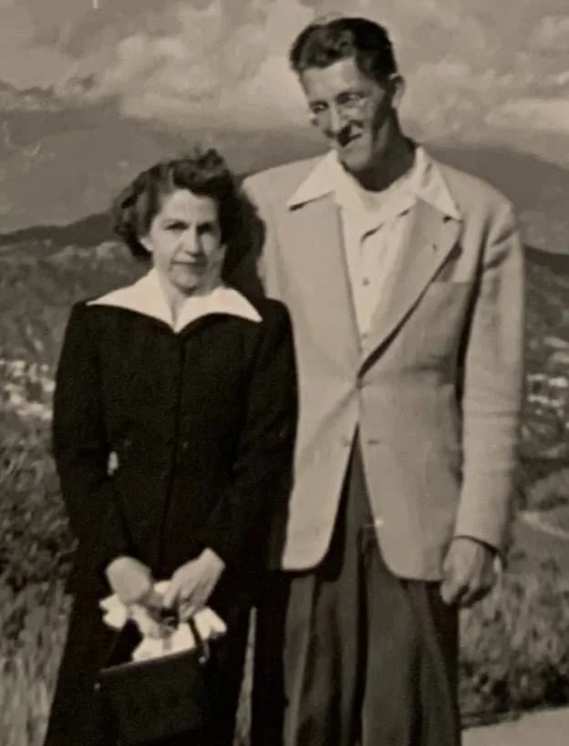 Black-and-white photo of my parents standing together outdoors, taken in their early years before our family changed.