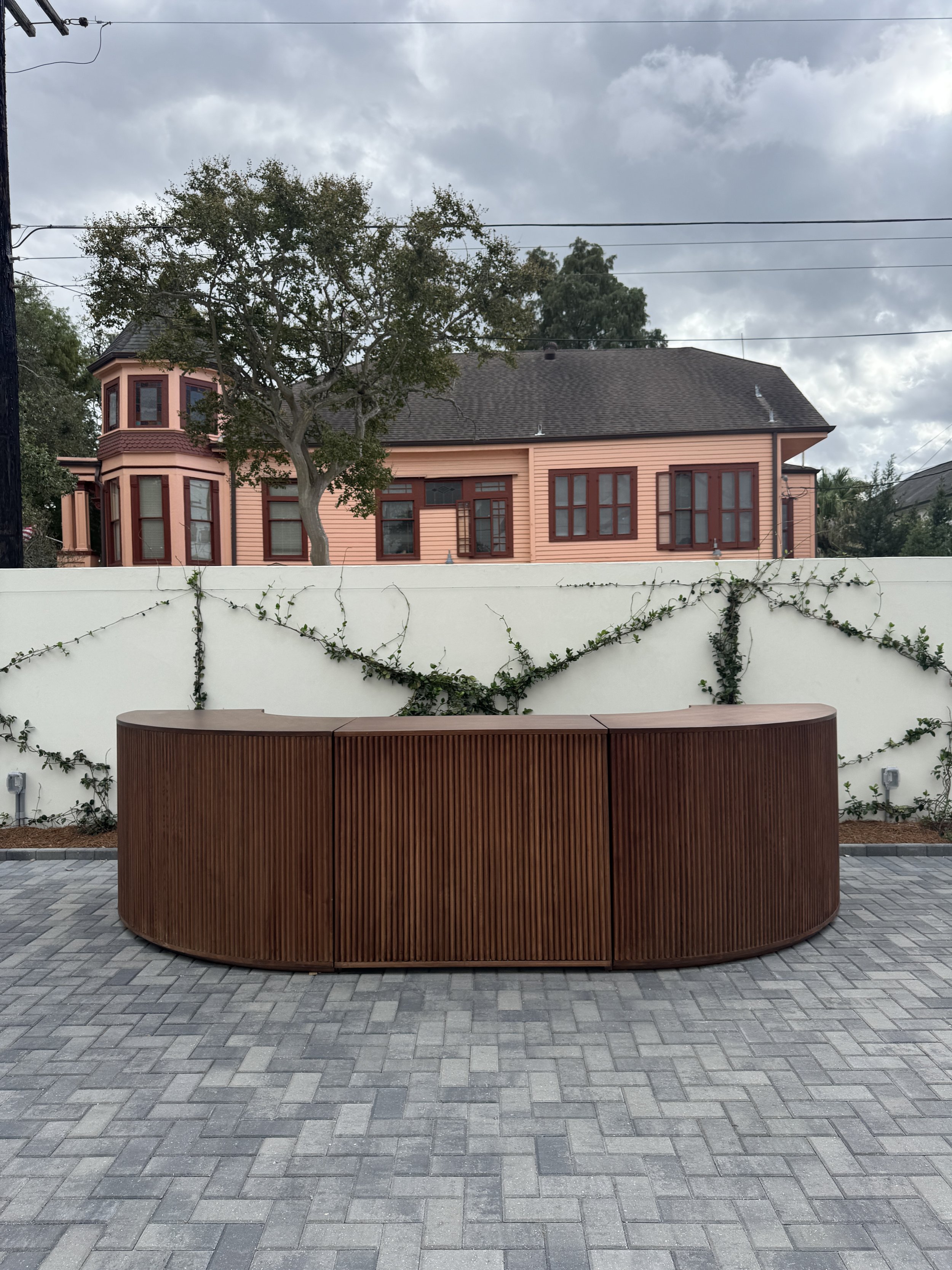 A outdoor wedding reception with an extended walnut round bar at the Josephine in New Orleans.