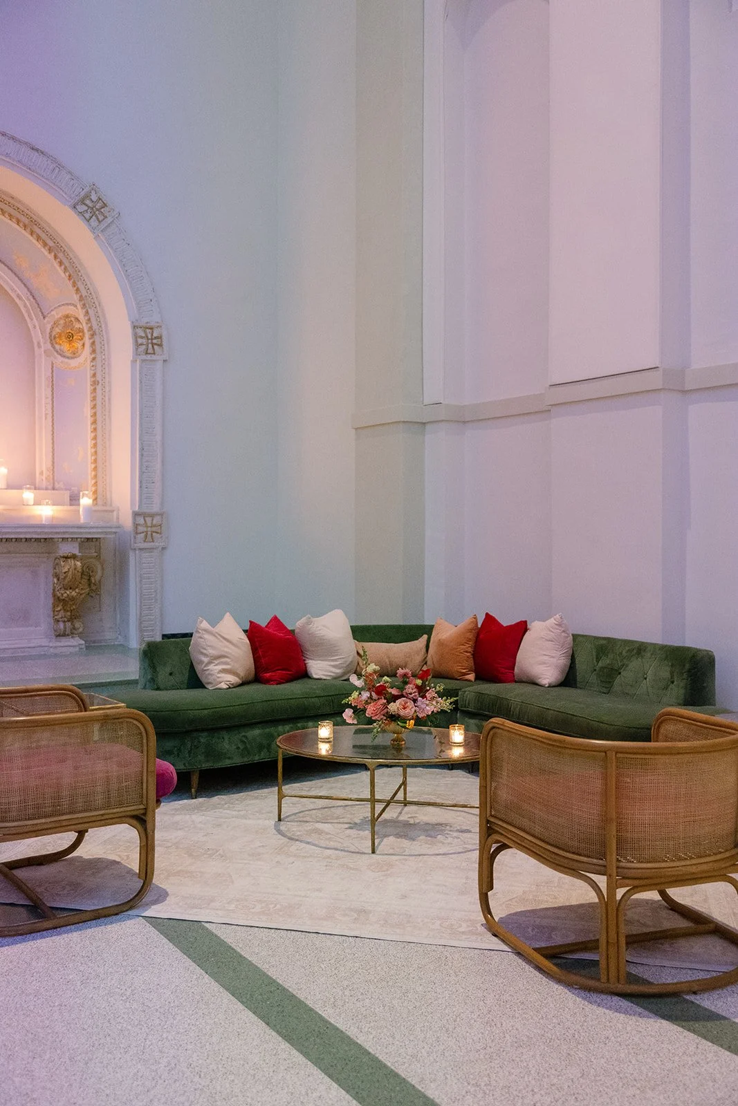 A wedding reception lounge with a green sectional and cane lounge chairs at the Josephine in New Orleans.