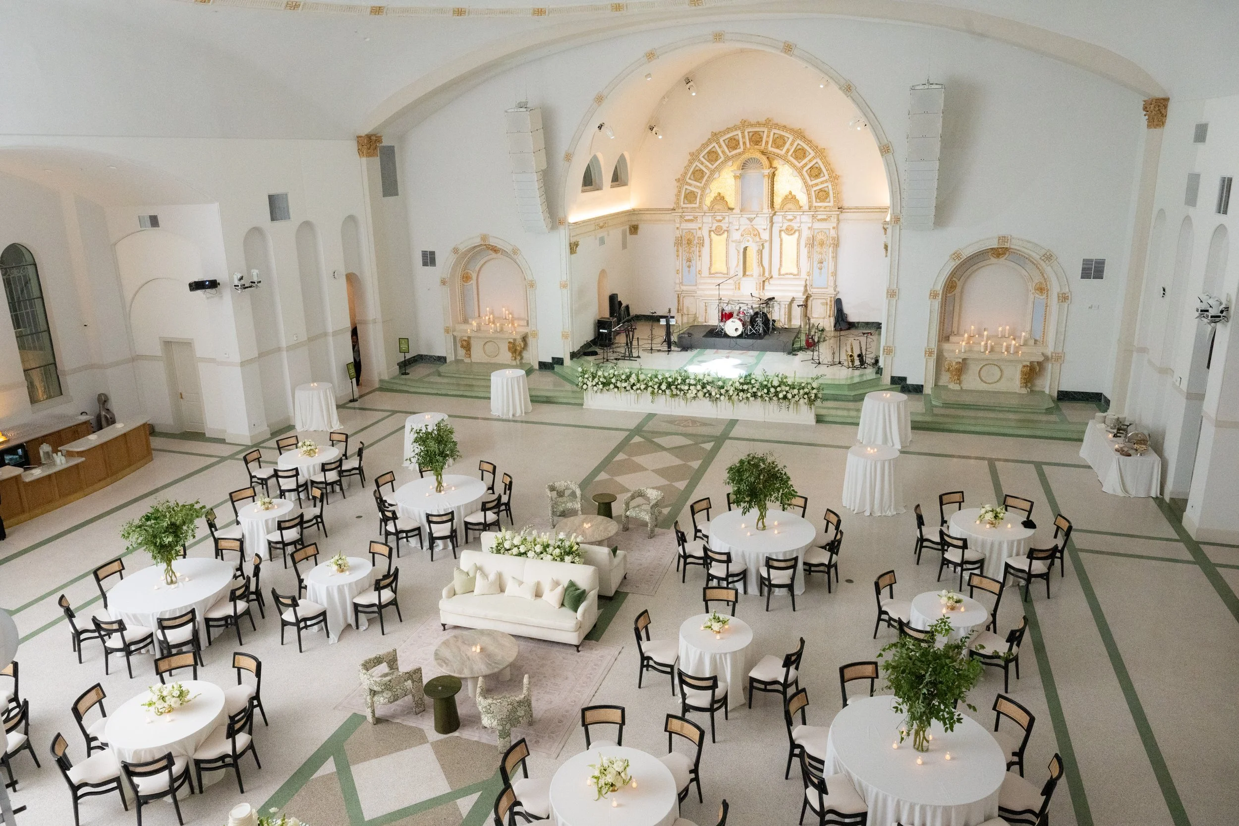 A wedding reception with black dining chairs and a cream and green lounge at the Josephine in New Orleans.