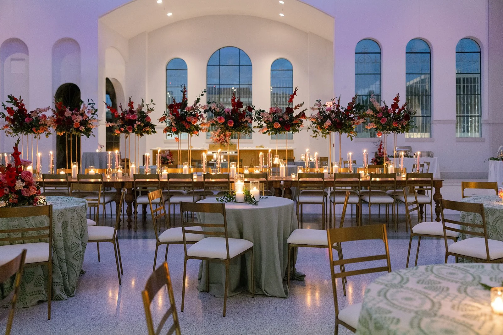 A wedding reception with gold dining chairs and dining tables at the Josephine in New Orleans.