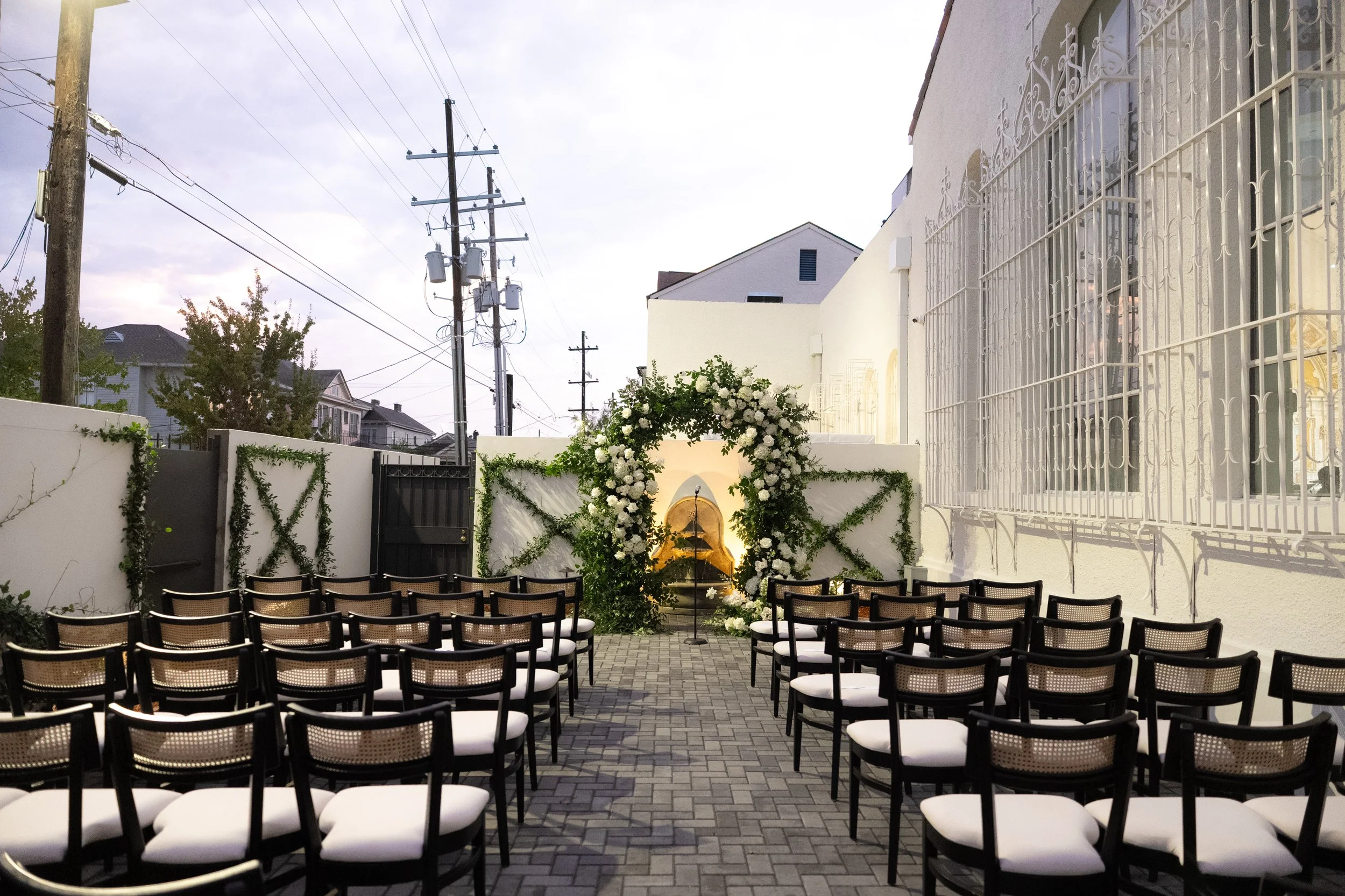 A outdoor wedding reception with black dining chairs at the Josephine in New Orleans.