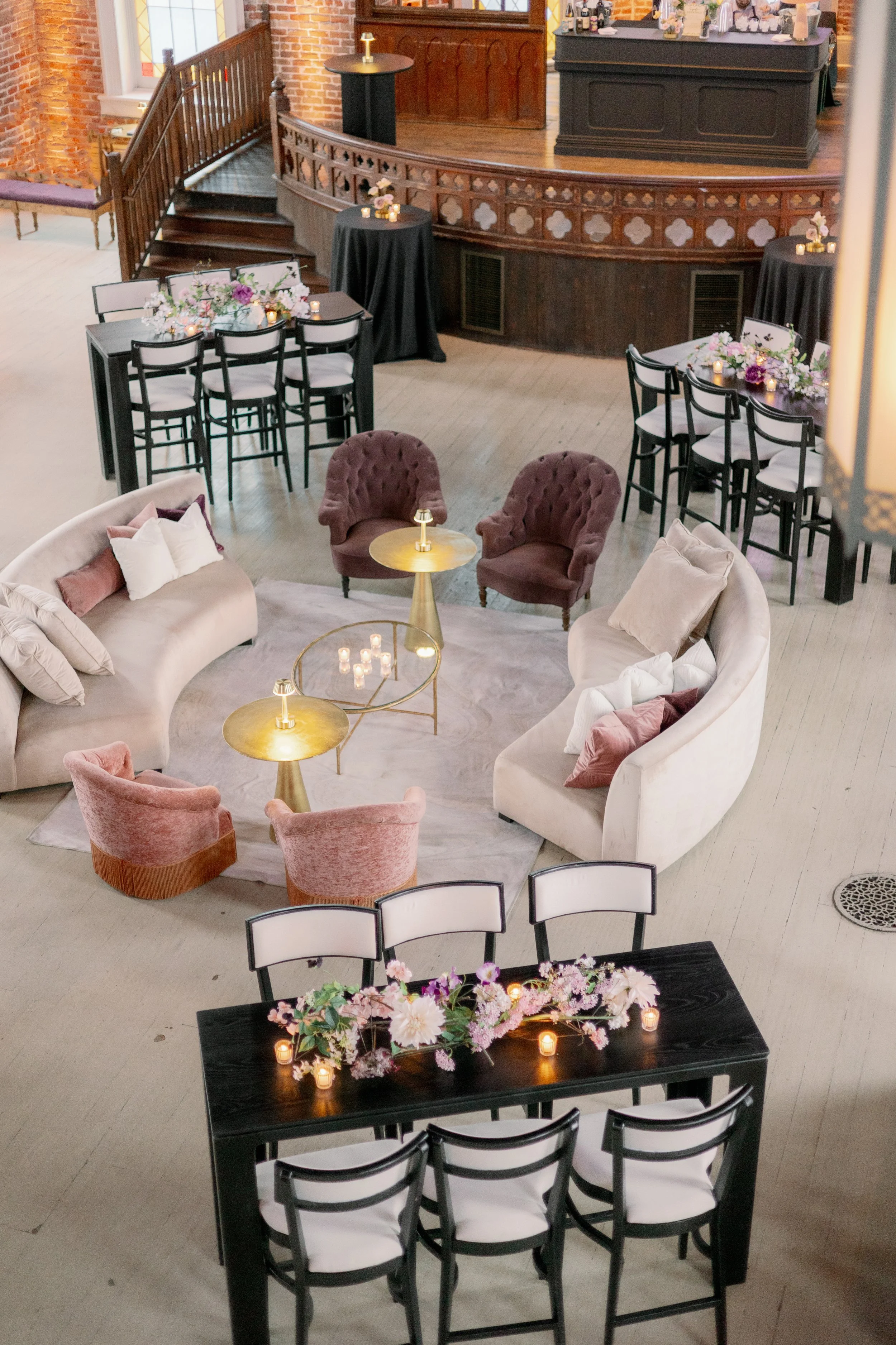 A wedding reception design with a full lounge, pub tables with black and cream barstools at Felicity Church in New Orleans.