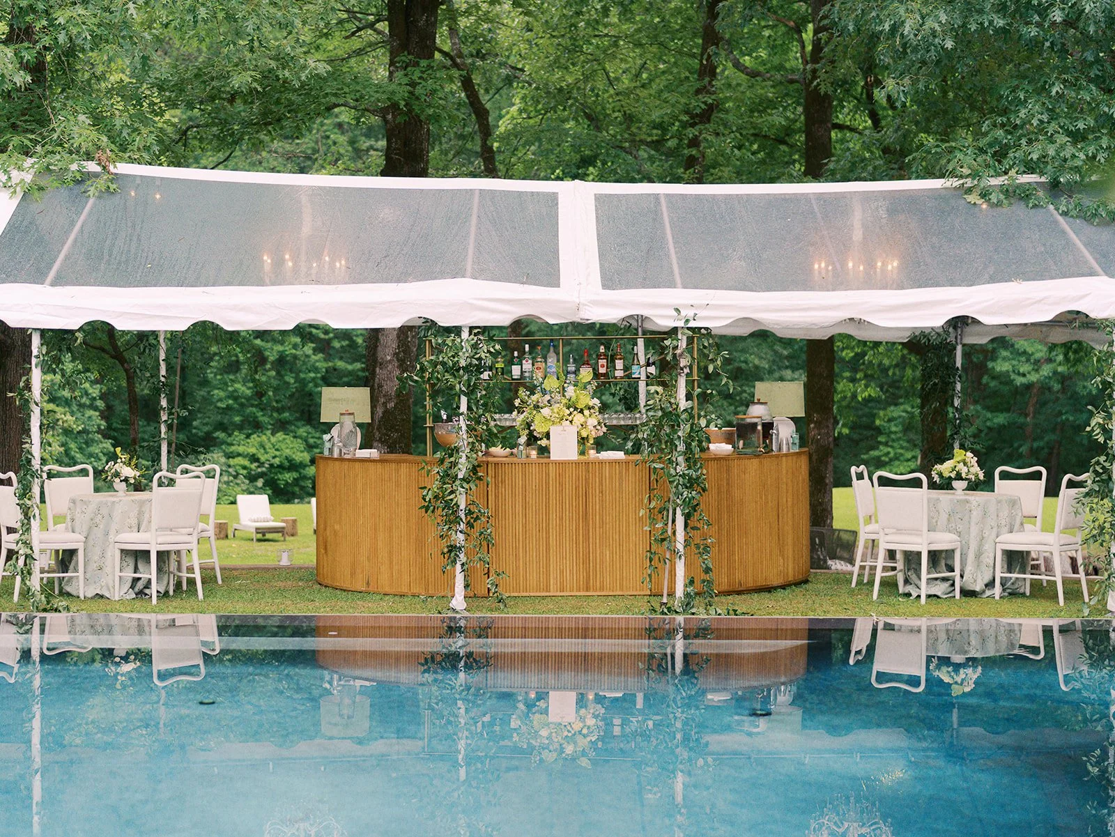 Luxury wedding reception design with a large oak wood bar with bar lighting at Field and Forest in Mississippi. 