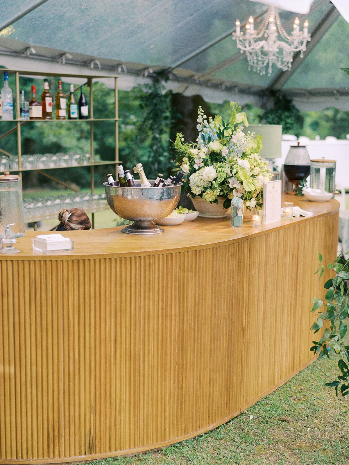 Luxury wedding reception design with a large oak wood bar with bar lighting at Field and Forest in Mississippi. 