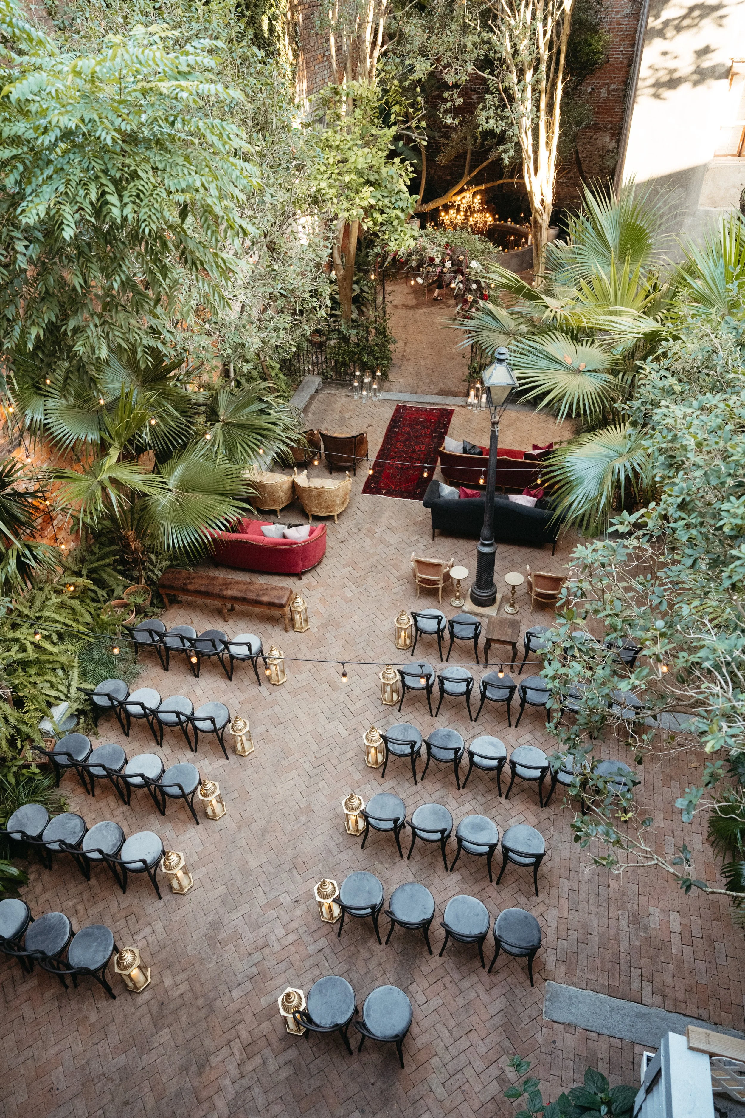 Mixed outdoor wedding ceremony seating with lounge sofas and chairs with black dining chairs at the New Orleans Pharmacy Museum.