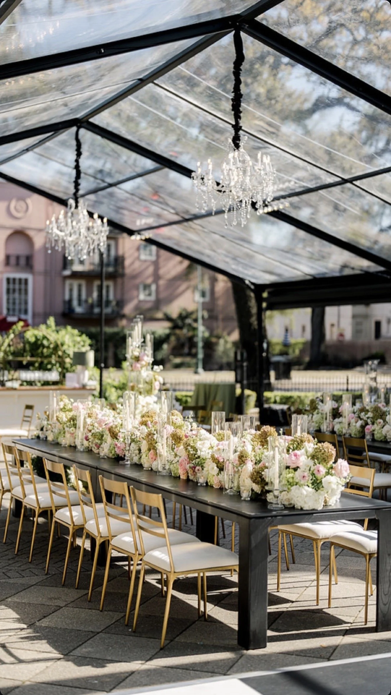 Wedding reception seated dinner with linen round back dining chairs and a wood dining tables at Elms Mansion in New Orleans. 