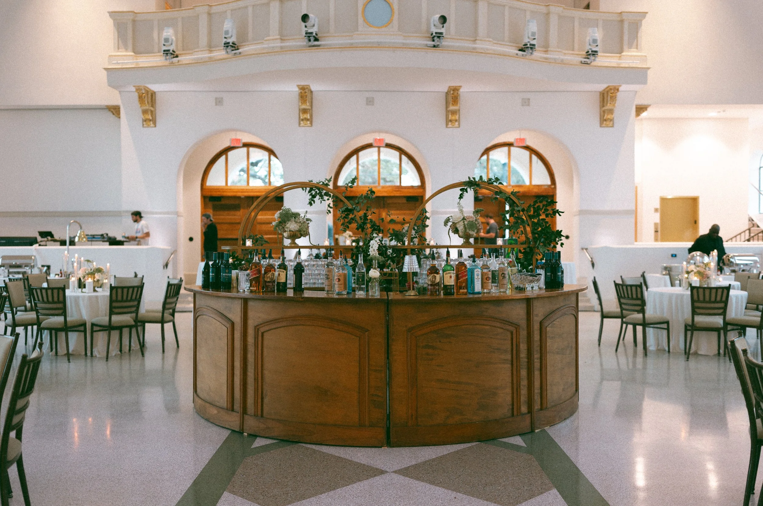 A wedding reception with a Natural wood round bar and gold barbacks at the Josephine in New Orleans.