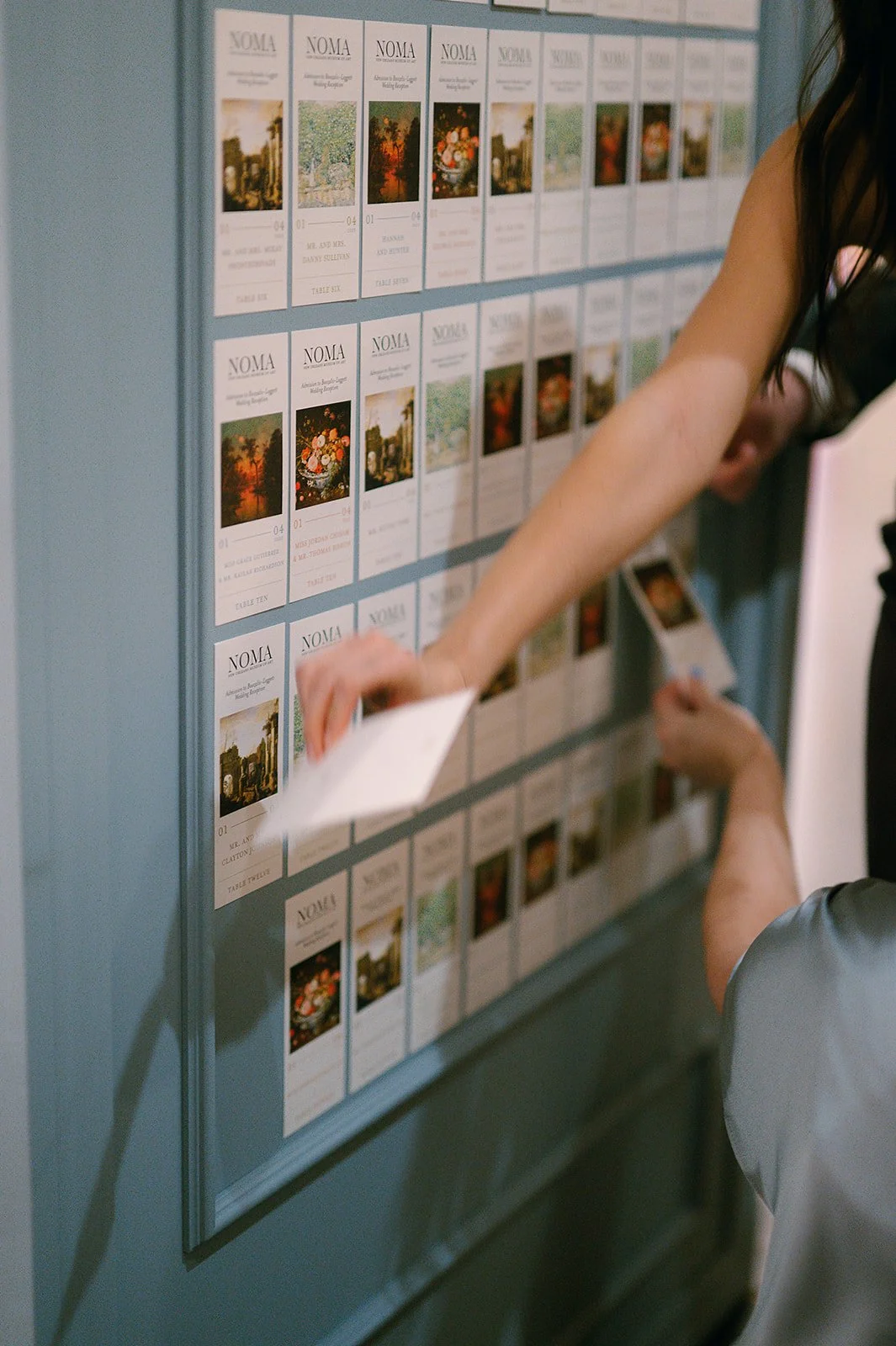 People browsing a bulletin board filled with event or exhibition flyers for NOMA, the North Carolina Museum of Art.