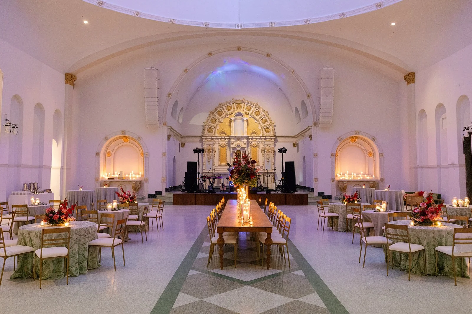 A wedding reception with oak wood dining tables and gold dining chairs at the Josephine in New Orleans.