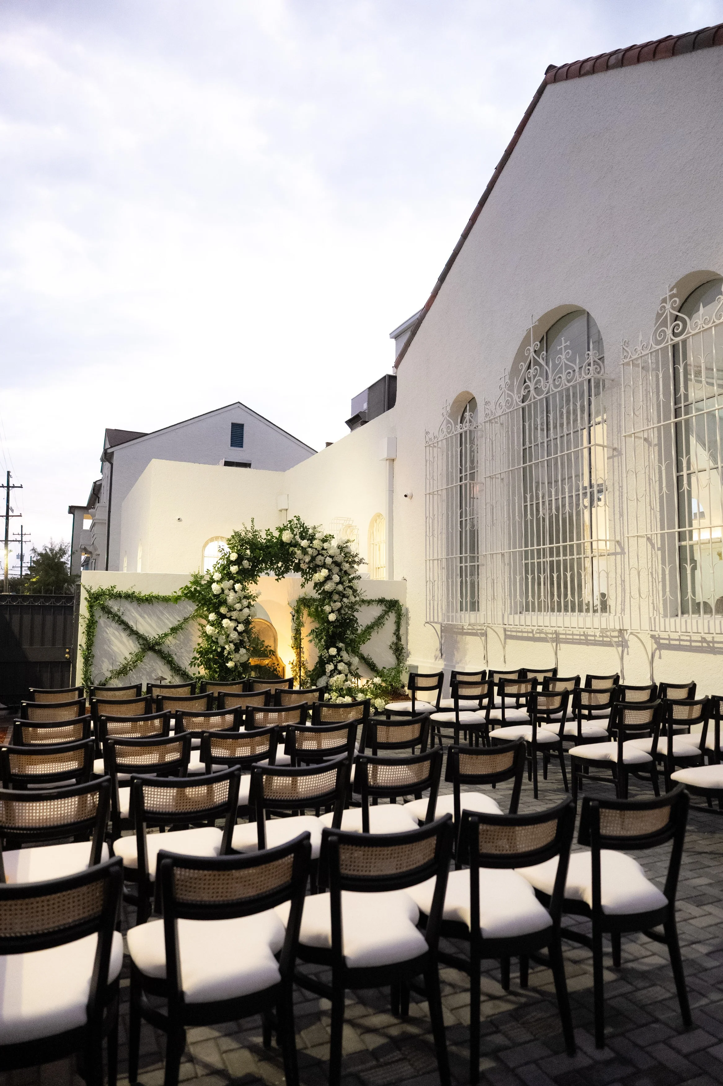 A outdoor wedding reception with black dining chairs at the Josephine in New Orleans.