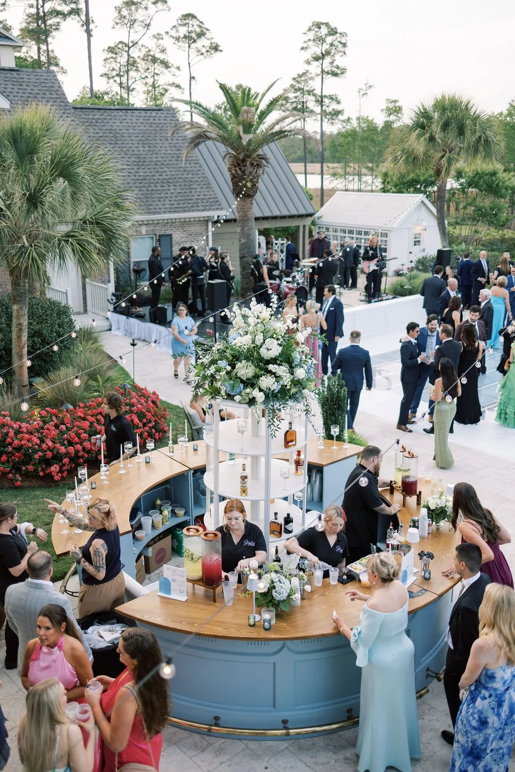 Guest enjoying an outdoor wedding with a light blue round bar in the Gulf South of Mississippi. 