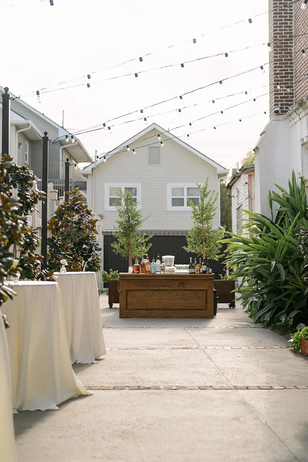 A outdoor wedding reception design with a wooden bar at Felicity Church in New Orleans.