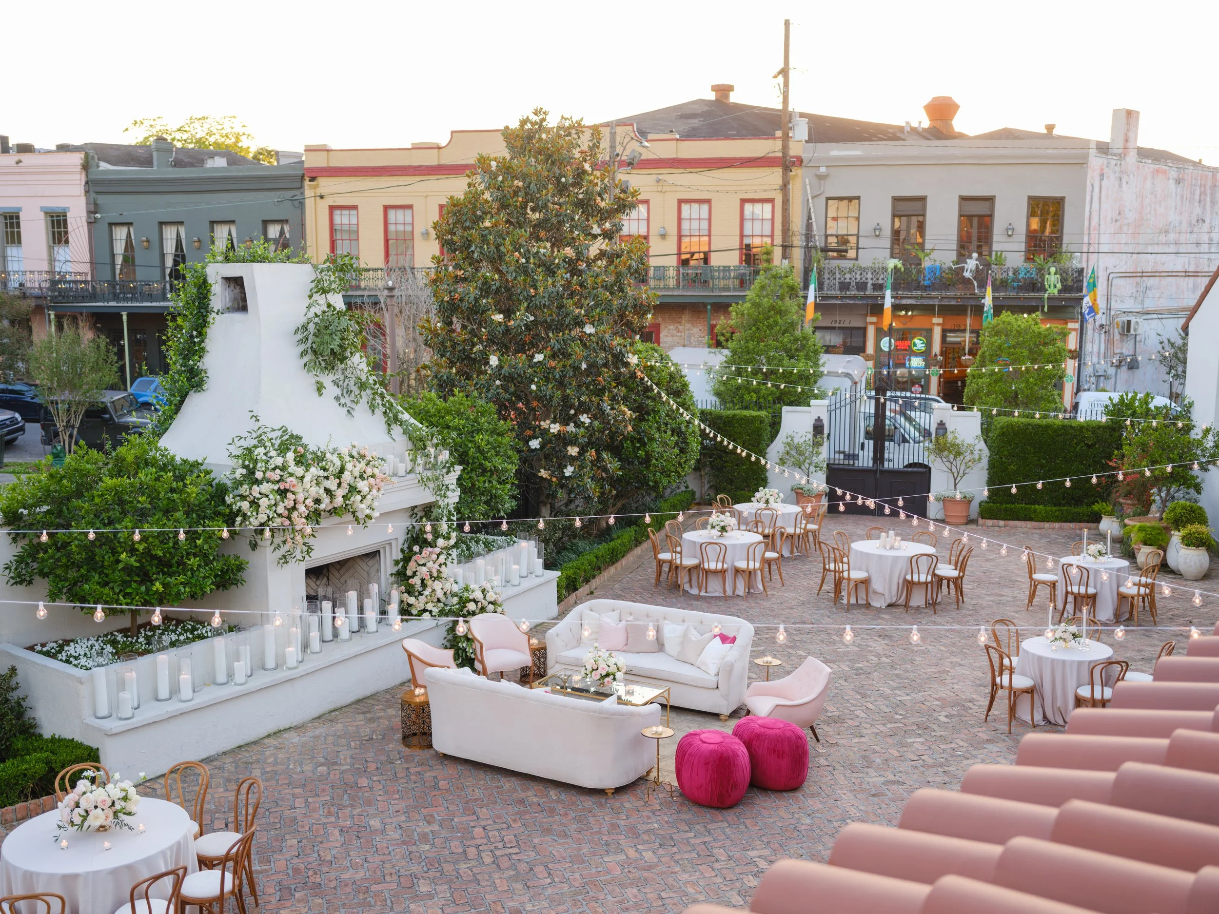 A courtyard wedding reception with a large lounge, dining chairs and tables at Il Mercato in New Orleans.