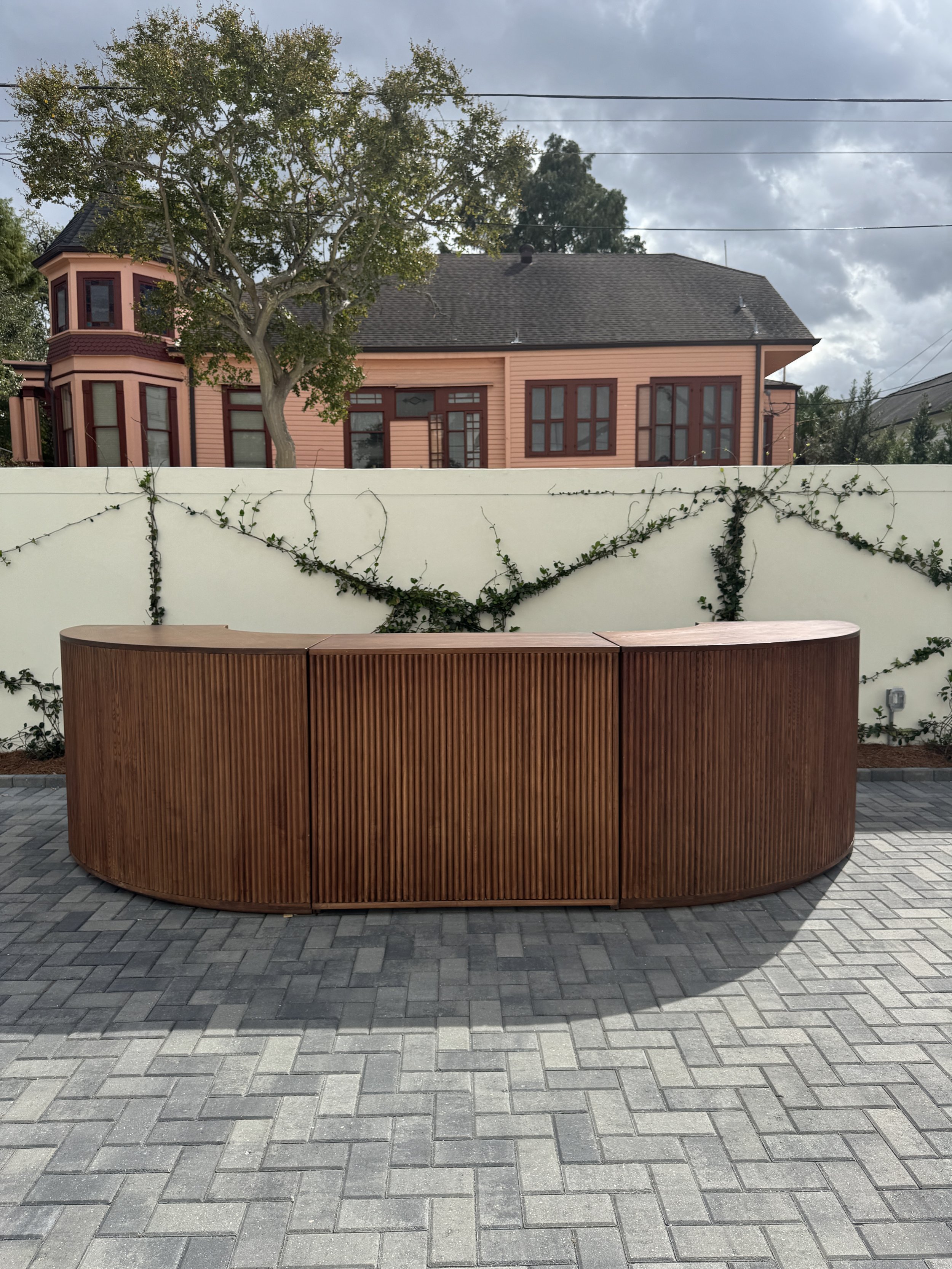 A outdoor wedding reception with a walnut round bar at the Josephine in New Orleans.