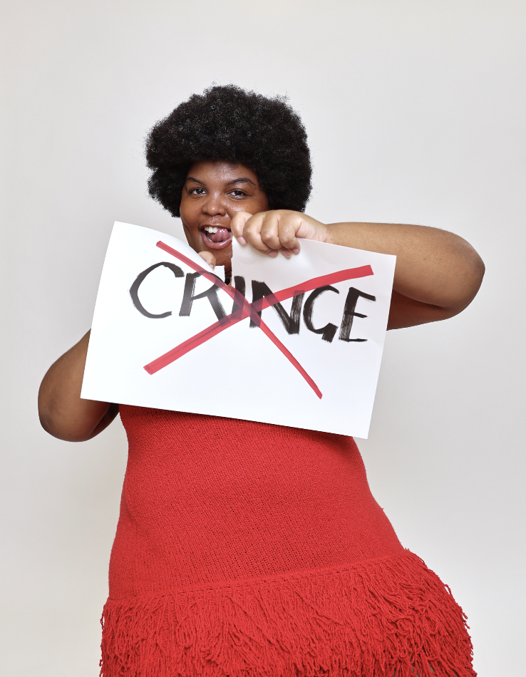 Woman ripping paper sign that reads "cringe" that is crossed out