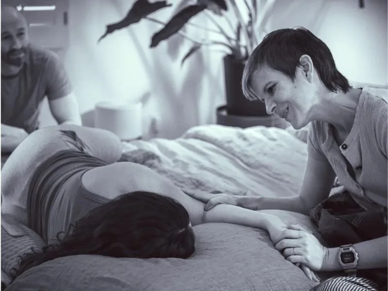 Doula Supporting her client in labor in a warm cozy home environment