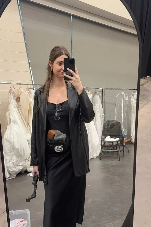 Woman holding iphone mirror selfie BTS runway fashion show