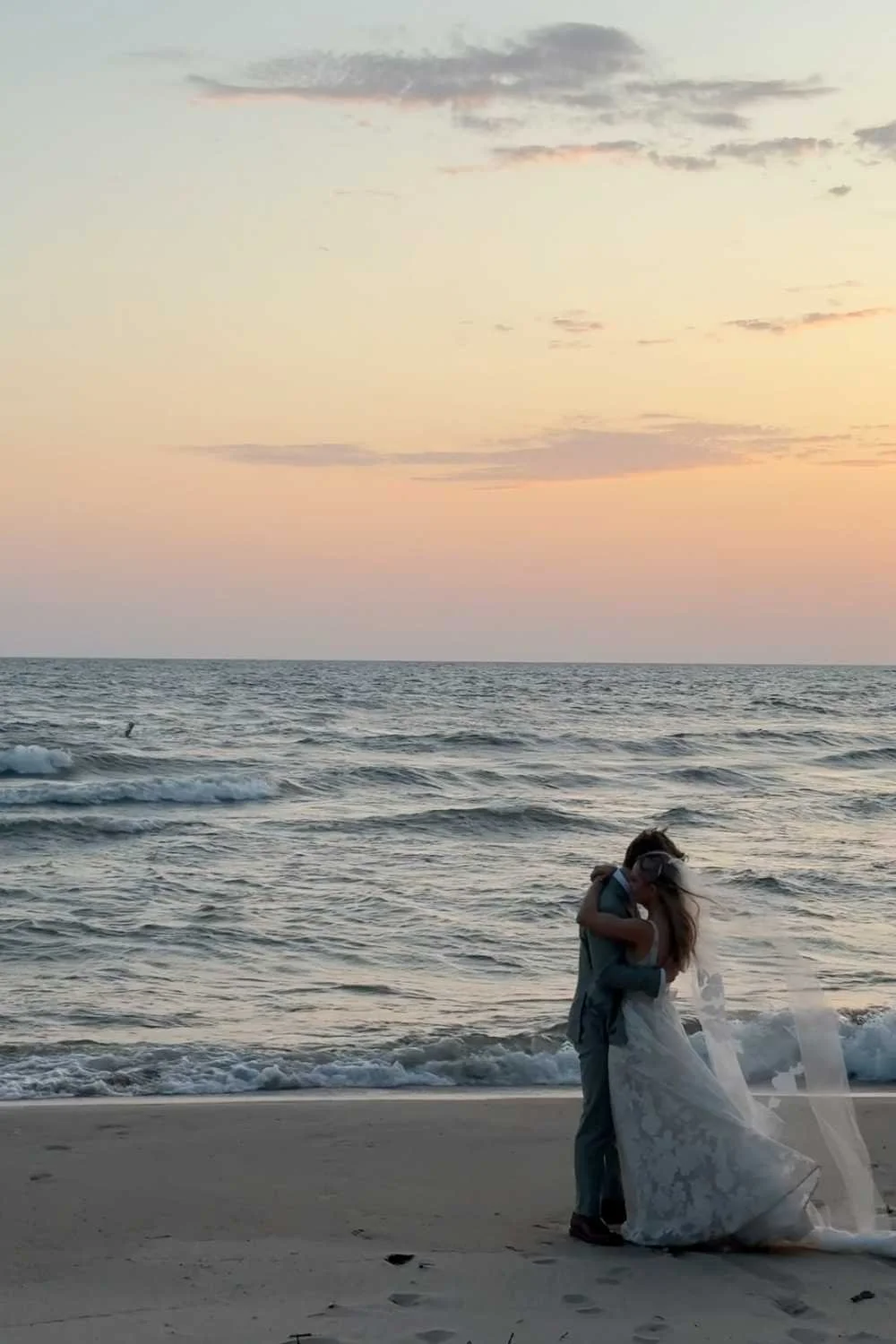 Wedding or special occasion table with white high-heeled shoes, wedding ring, invitation cards, stamps, tissue box, gift box, and decorative items, with sunlight streaming through a window overlooking greenery.