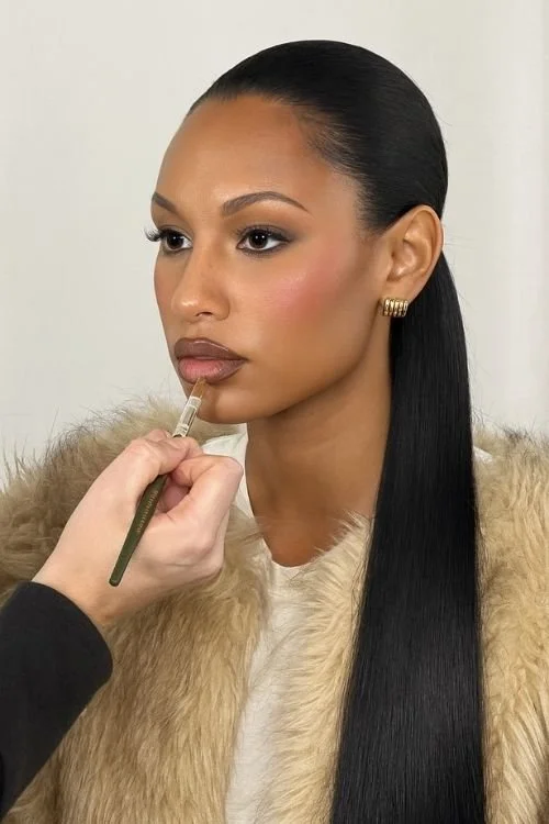 A woman posing for photos in a photography studio with a white backdrop