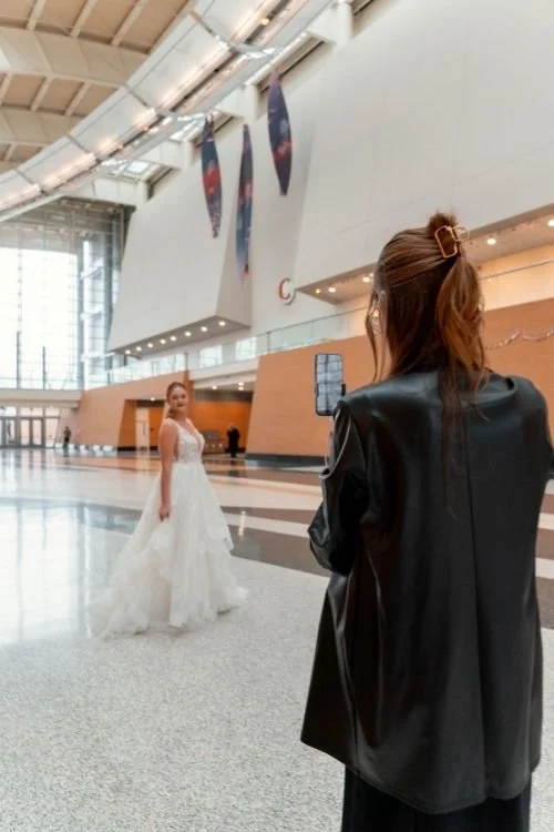 Woman holding phone taking photo of bride