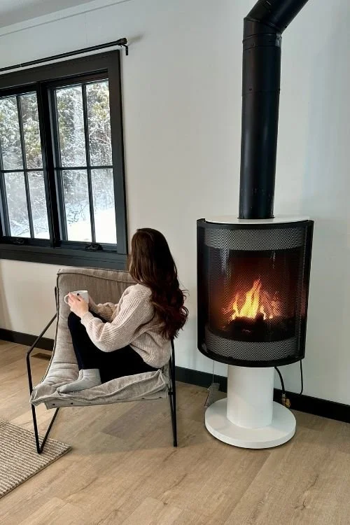 Woman sitting in cabin comfy with space heater